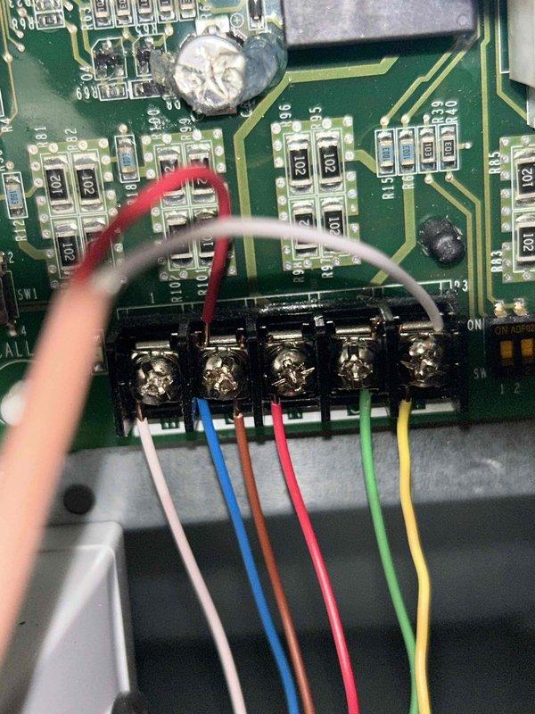 Diagnosed no cooling issue on a 2-year-old system. Found disconnected low voltage wiring at the control board with no Y and C connection. Removed aftermarket C-wire adapter module that was causing communication failure, then rewired the system with direct connections from original wires to a Honeywell T4 thermostat instead of the Nest. System now functioning properly with both cooling and heating operations confirmed.
