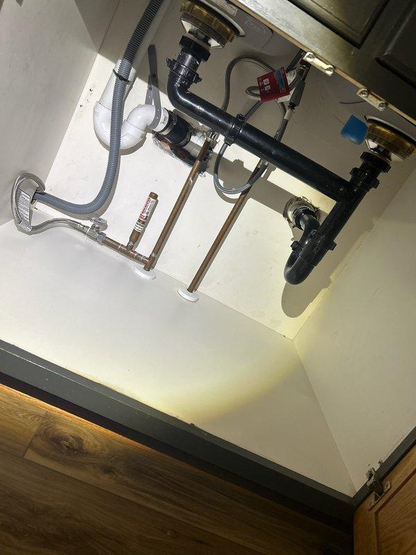 Responded to service call for kitchen sink backup. Investigation revealed drainage issues when sink and dishwasher were in use, despite clear P-trap. Successfully restored proper drainage function by augering the kitchen sink line, clearing blockage located beyond the trap assembly.