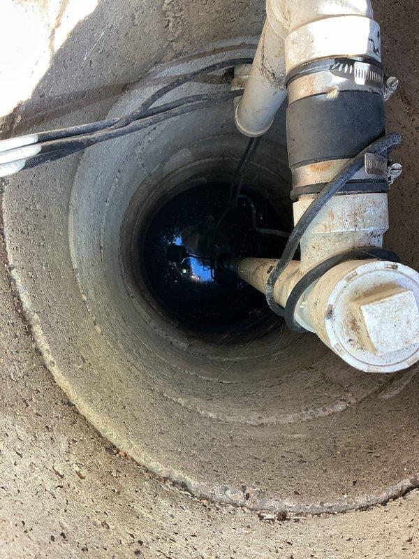 Responded to service call regarding basement backup issue. Upon inspection of customer's septic system, discovered standing water in concrete drainage well with multiple PVC pipe connections. After assessment, determined backup was caused by septic system failure rather than standard clogged drain. Notified customer of findings and explained septic issue requiring specialized service.