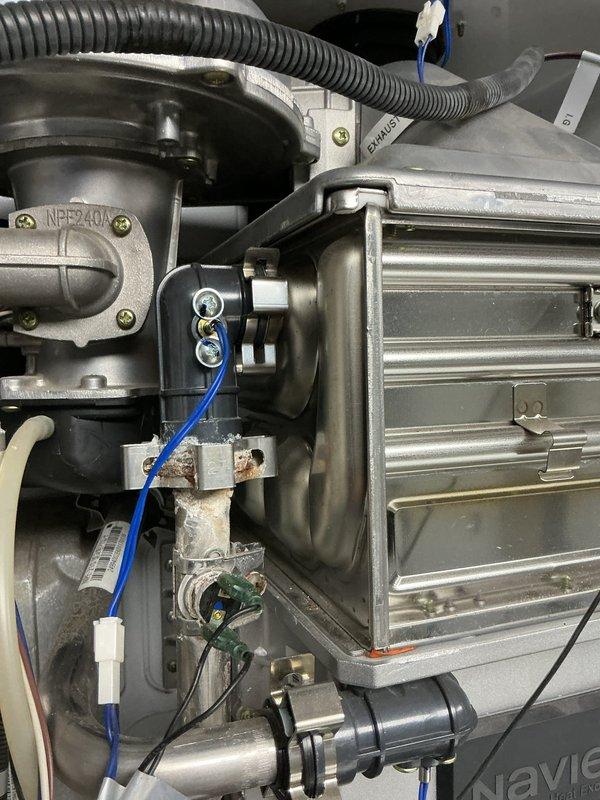 Inspected Navien tankless water heater (model NPE2400) exhibiting error codes and found significant corrosion around the recirculation pump and heat exchanger. Recommended tuneup service to address these issues. Also assessed backing up urinal and recommended augering to clear the blockage.