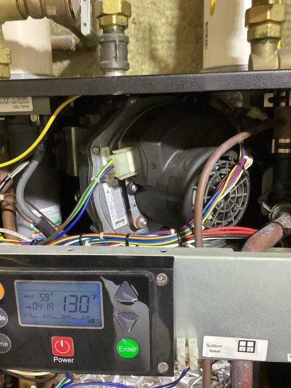 Inspected non-functioning boiler system that was presenting an E1 error code (blower speed fault). Confirmed damaged blower fan with significant noise issues and discovered a large hole in the exhaust elbow at the bottom of heat exchanger. Informed customer that the boiler brand is no longer manufactured or supported, and customer has elected to proceed with complete boiler replacement.