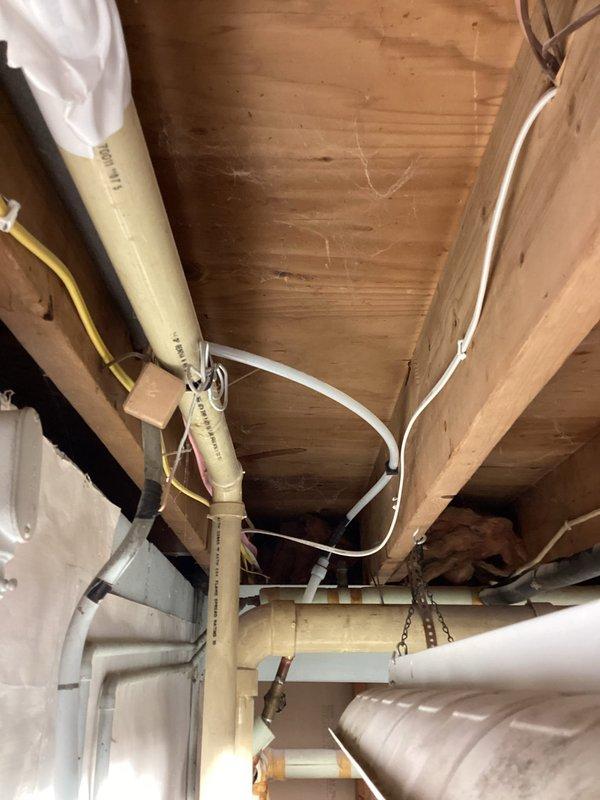 Completed installation of a new frost free hose bibb after cutting back the existing spigot from the rock wall removal area. Work included connecting the new frost free fixture to the existing plumbing infrastructure visible in the crawlspace, ensuring proper installation through the house wrap barrier during the ongoing construction phase.