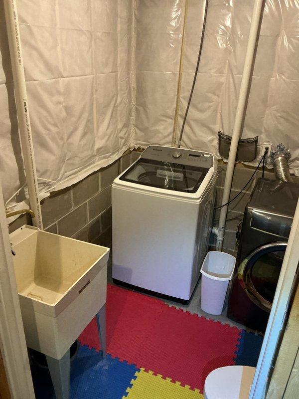 Conducted a comprehensive plumbing inspection of the property's water supply system and laundry room. Examined the water softener tank, copper and PVC piping configurations, pump assembly, and various connection points for proper function and integrity. Also verified working condition of the laundry appliances including washer, dryer, and utility sink with no issues identified requiring immediate attention.