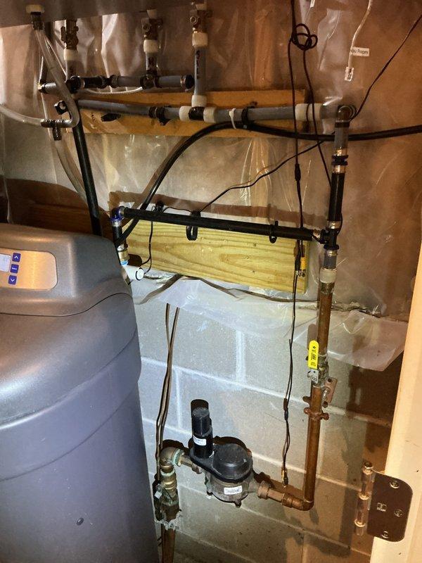Conducted a comprehensive plumbing inspection of the property's water supply system and laundry room. Examined the water softener tank, copper and PVC piping configurations, pump assembly, and various connection points for proper function and integrity. Also verified working condition of the laundry appliances including washer, dryer, and utility sink with no issues identified requiring immediate attention.