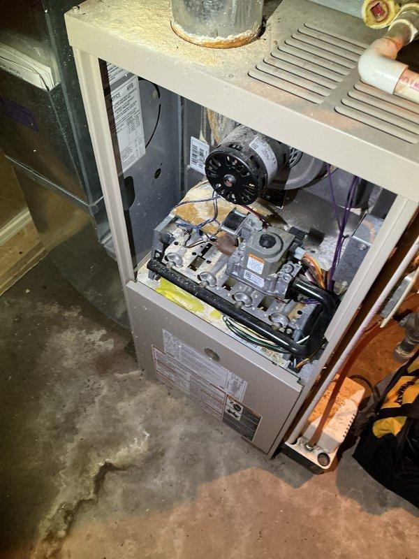 During inspection of the 22-year-old HVAC system, diagnosed multiple critical failures including damaged exhaust venting, blower motor leaking oil, and corroded ignition components. Due to these significant safety concerns, performed a system shutdown. Recommended complete system replacement as primary option, with alternative solutions being replacement of blower motor and ignition assembly along with exhaust vent repairs.