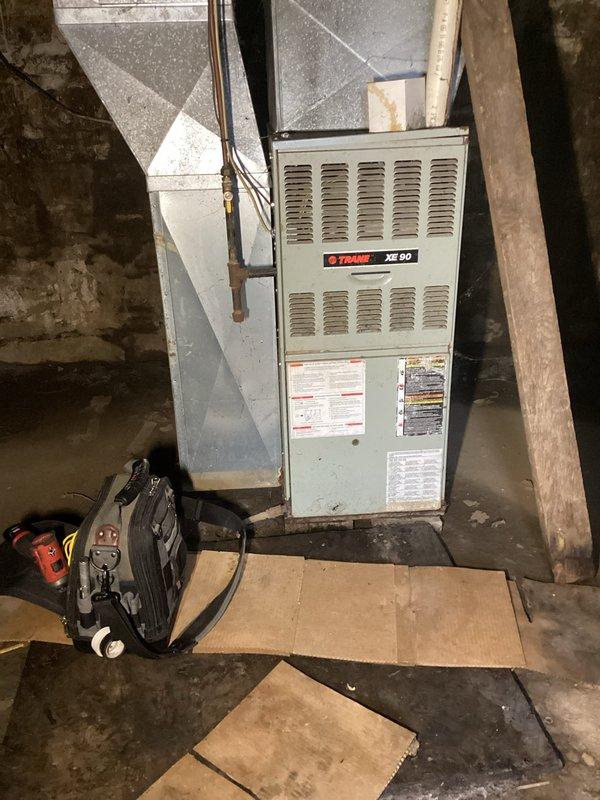 Responded to service call for an aging Trane XE 90 furnace making loud noises. Diagnostic inspection revealed a mouse trapped in blower wheel causing severe vibration and noise. Further examination uncovered extensive rust damage throughout the unit and two holes in the heat exchanger, requiring equipment to be tagged out for safety. Due to the deteriorated condition, repair not recommended; scheduled service advisor to discuss replacement options with customer.