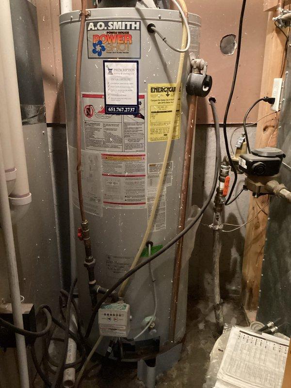 Diagnosed and identified 21-year-old 40-gallon A.O. Smith power vent water heater with active tank leak requiring full replacement. Noted existing cellular core vent piping that would not meet current code requirements during inspection, with potential need for complete re-venting to roof. Customer presented with replacement options and advised of possible additional venting work pending inspection outcomes.