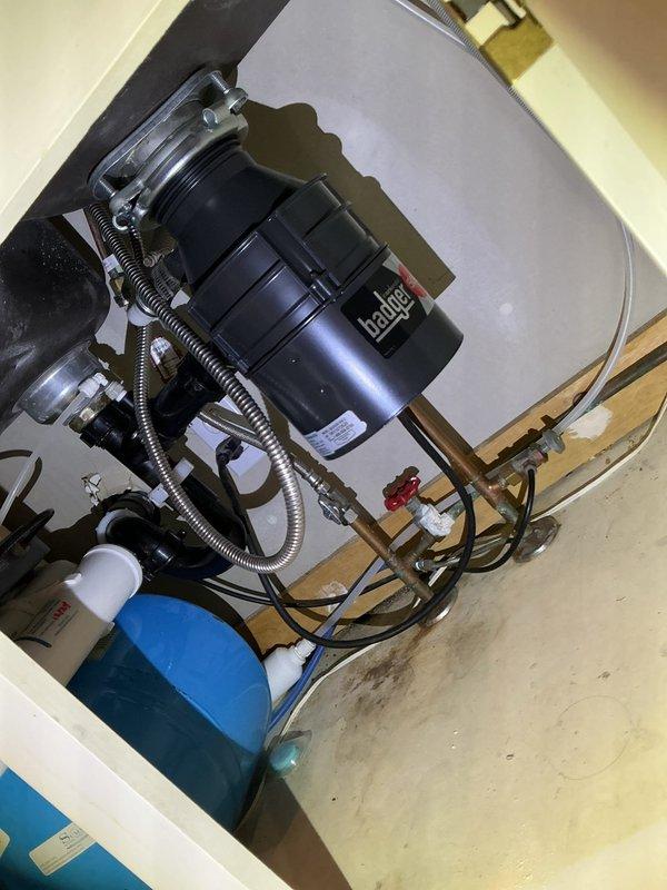 Responded to service call for malfunctioning garbage disposal that was making unusual noise and odor. Diagnostic testing revealed motor failure evidenced by continuous humming when activated despite reset attempts. Removed old Badger unit and installed new garbage disposal, ensuring proper connections to existing plumbing infrastructure including drain pipes and water supply lines.