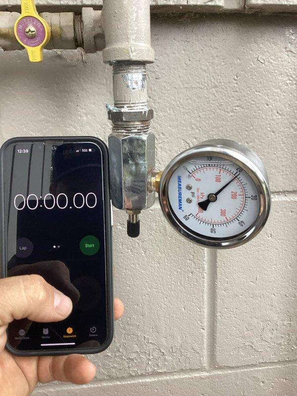 Conducted re-inspection with White Bear Township officials for generator installation, which received final approval. Completed system setup including purging gas lines, configuring settings, setting system to auto mode, and verifying proper operation of generator and garage heater. Documentation includes photos of gas line connections and pressure gauge reading approximately 50-60 PSI.