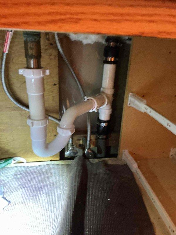 Resolved clogged bathroom sink drain by augering the lavatory line to restore proper drainage. Repaired water leak by replacing damaged section of piping behind shower, which included installing new hot water valve to prevent further water intrusion into wall cavity. All plumbing systems now functioning correctly with no visible leaks.