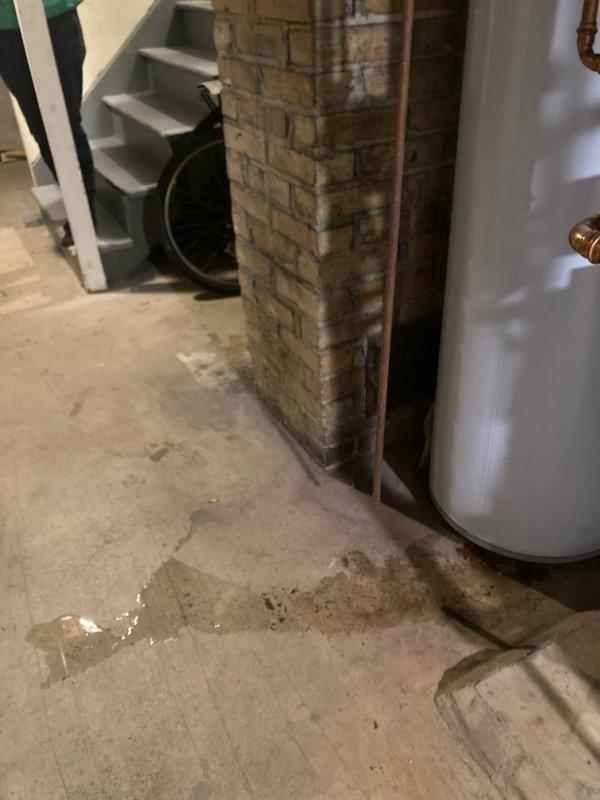 Replaced leaking 40-gallon natural gas tank water heater with customer-approved 50-gallon model. Original unit showed visible water pooling at base and significant bottom corrosion. New installation included proper connections to existing gas line and ventilation system, with all plumbing connections tested for leaks.