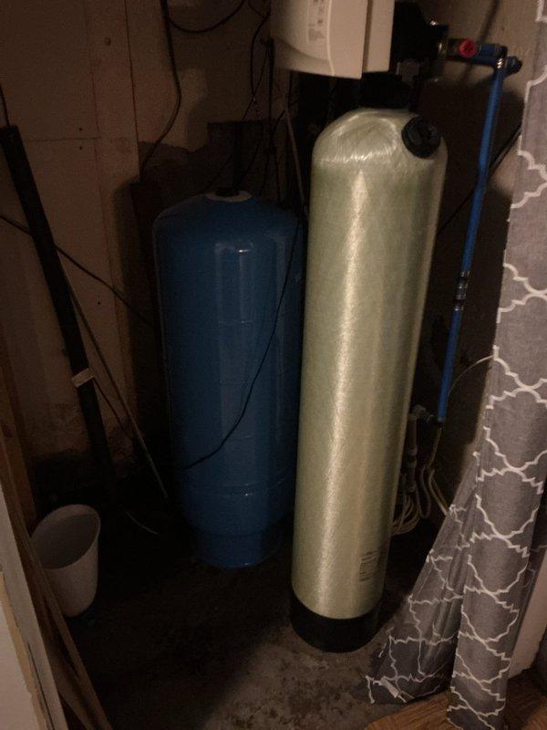 Responded to emergency call for copper pipe burst in basement with customer unable to completely shut off water source. Determined pressure tank had ruptured and electrical panel lacked proper labeling for well pressure pump. Located correct fuse and panel, shut off water to the well, and replaced damaged pressure tank with equivalent model to restore proper system functionality.
