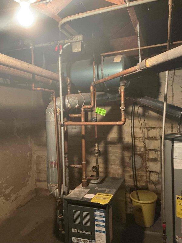 Diagnosed no heat issue on Weil McLain boiler where thermostat was found to be non-functional. Confirmed boiler operation by manually jumping R to W terminals. Discovered low system pressure indicating potential leak; added water and advised customer to monitor. Customer opted to replace batteries and possibly thermostat themselves, declining full system tune-up due to current non-operational status.