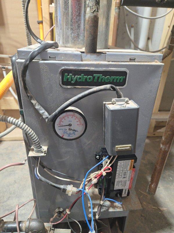 Diagnosed 5-year-old HydroTherm boiler with no heat issue. Investigation revealed disconnected thermostat wire that wasn't properly secured in terminal. Repaired connection by properly inserting wire into terminal, restored signal path from thermostat to control system. Tested full system operation after repair, confirming proper ignition sequence and normal heating function.