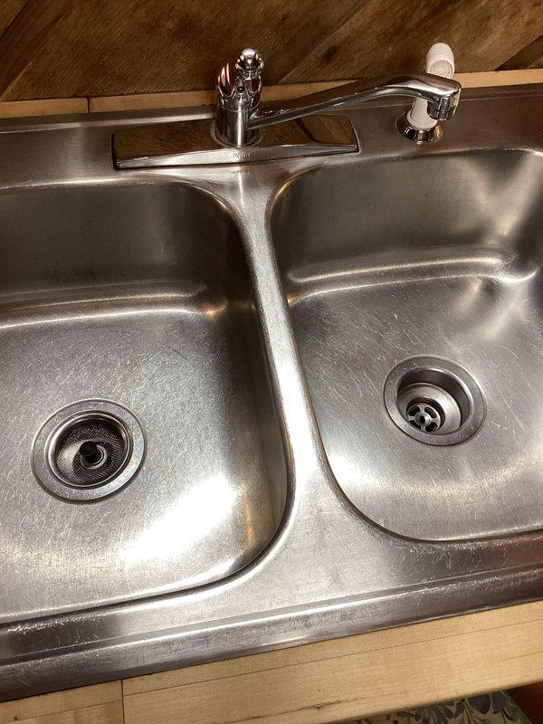 Responded to service call for kitchen sink leakage. Upon inspection, found deteriorated sink baskets and drain assembly with visible corrosion. Replaced both sink baskets and drain assembly in the double-basin stainless steel kitchen sink, resolving the leak issue. Additionally, adjusted sticking toilet lever mechanism to restore proper function.