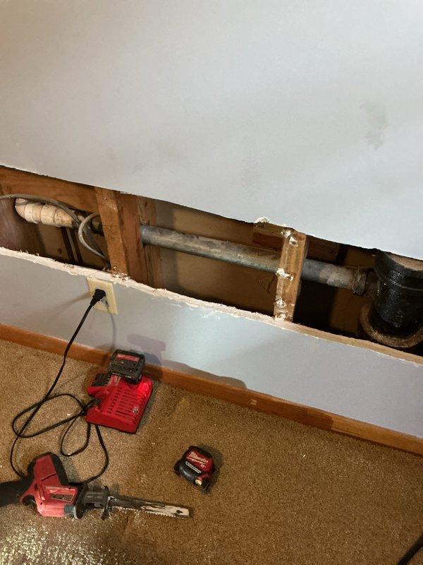 Responded to a water leak issue where the bathroom sink drain was leaking into the basement. Upon inspection, found severely corroded galvanized drain pipe with significant mineral buildup and deterioration. Created access through the wall, removed the damaged section, and installed new drain line components to resolve the leak.