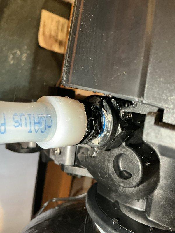Replaced damaged drain connections on water softener and acid neutralizer that were leaking and causing water accumulation on basement floor. Original softener drain piece was cracked due to over-tightening; ordered replacement part after completing temporary repair to resolve immediate leak issues.
