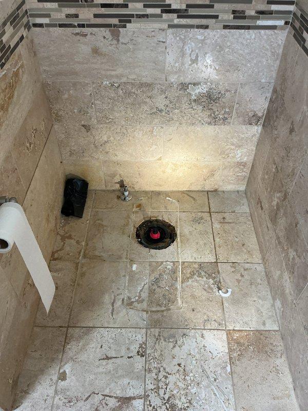 Performed toilet reset following flood damage remodel. Located and capped abandoned dish drain line that was extending from ceiling. Verified proper drainage and sealing of newly reset toilet fixture.