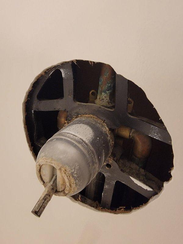 Replaced worn shower valve assembly in vacant property as per customer request. Accessed valve through wall opening, removed corroded original component showing significant mineral buildup and water damage. Installed customer-supplied replacement valve and verified proper operation before departure.