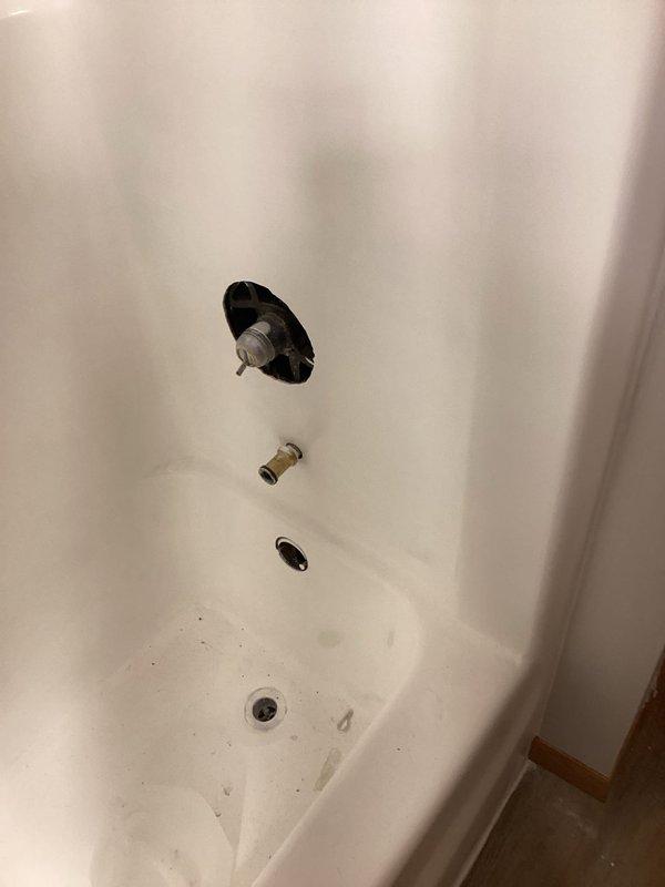 Replaced worn shower valve assembly in vacant property as per customer request. Accessed valve through wall opening, removed corroded original component showing significant mineral buildup and water damage. Installed customer-supplied replacement valve and verified proper operation before departure.