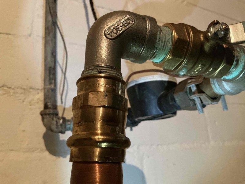 Responded to customer location to address leak at water meter inside the home. After city water department performed scheduled shutoff, replaced failed fittings at the meter that were originally installed during city's service line replacement approximately one year ago. Successfully restored water service with new professional-grade shut-off valve and fittings, eliminating the leak at the meter connection.