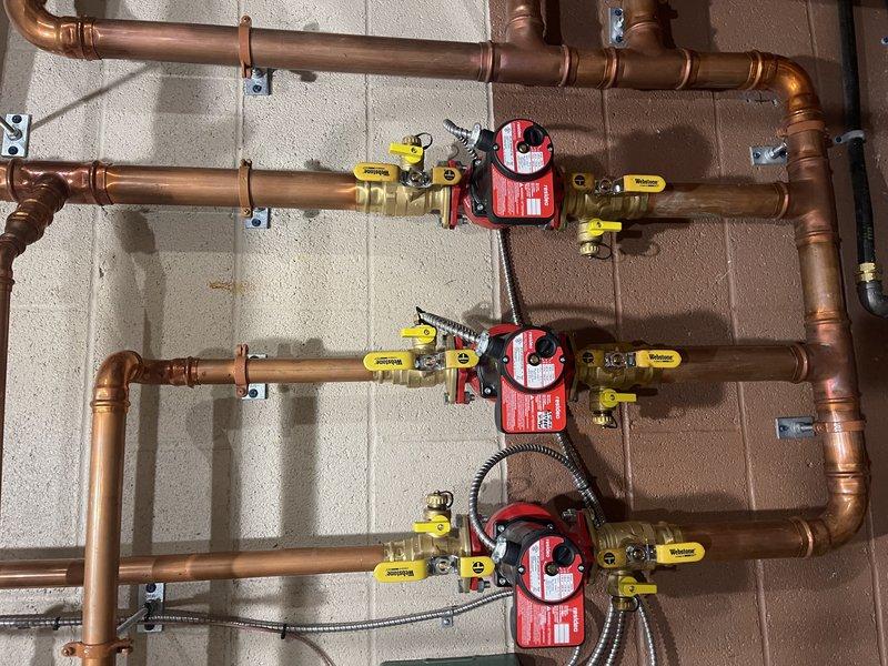 Diagnosed failing circulation pumps in commercial boiler system; identified bearings failing in control area/boardroom pump and seized pump for boiler nearest door. Temporarily resolved issues by deactivating problematic boiler and reducing speed on functioning pump while recommending replacement of both damaged pumps.