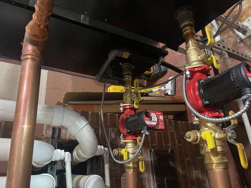 Diagnosed failing circulation pumps in commercial boiler system; identified bearings failing in control area/boardroom pump and seized pump for boiler nearest door. Temporarily resolved issues by deactivating problematic boiler and reducing speed on functioning pump while recommending replacement of both damaged pumps.