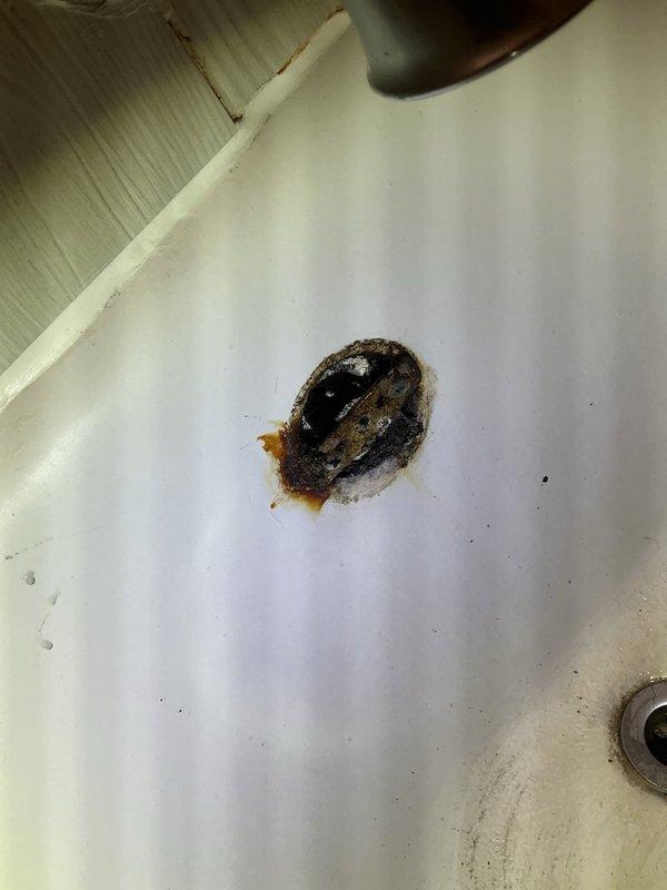 Responded to service call for clogged bathroom sink and tub drains in upper unit. Upon inspection, discovered significant corrosion and mineral buildup in the sink drain area causing the blockage. Despite standard drain clearing procedures, was unable to fully restore proper drainage due to the extent of deterioration in the drain system.