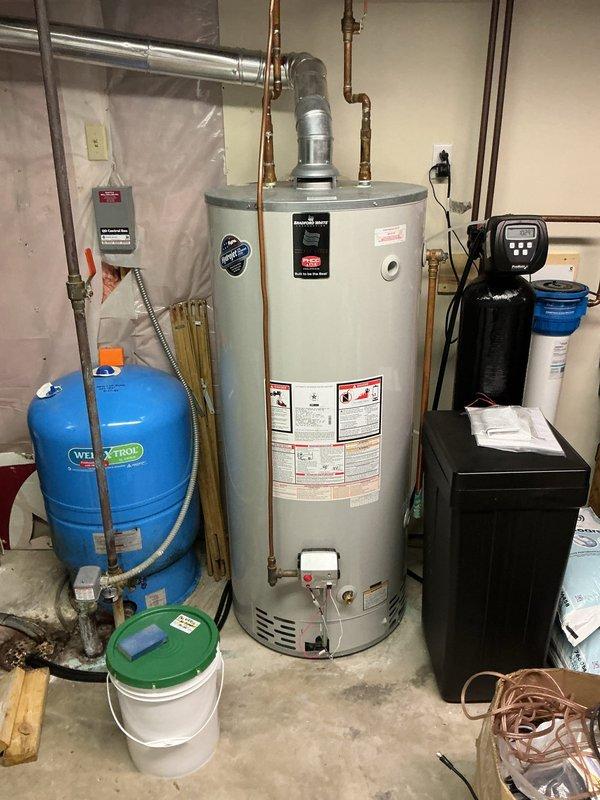 Responded to service call for loose faucet issue. Performed maintenance by tightening handle and cleaning the faucet assembly. Also inspected water heater system and associated plumbing components, noting corrosion on vertical pipe and mineral buildup requiring future attention.