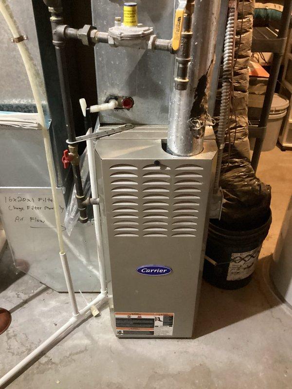 Performed routine maintenance on 18-year-old Carrier furnace that is nearing end of life expectancy (15-20 years). System is operating safely with appropriate gas pressures, cleaned flame sensor, verified proper ignitor function, and confirmed good amp draws on inducer and blower motors (0.94A). Heat exchanger shows some dark spotting; filter and condensation drains are clear.