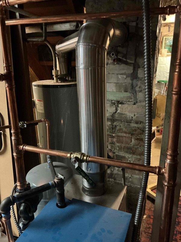 Responded to no heat call for 4-year-old Slant Fin boiler. Diagnosed failed flame rollout switch preventing ignition. Temporarily jumpered switch to test system operation; no actual rollout condition observed during 30-minute test period. Detected minor CO leakage (4ppm) at lower right jacket seal. Replaced rollout switch to restore heat and advised homeowner about potential issues with chimney draft during high winds.