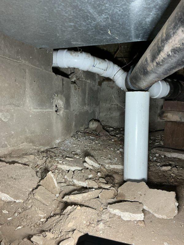 Responded to a leaky toilet issue reported by customer, which investigation revealed was caused by clogged lines resulting from improperly graded sewer pipes in poor condition. After assessment, provided a comprehensive solution that included complete re-piping of the affected plumbing system. Documented the repair area showing corroded copper pipes with significant oxidation in the crawlspace/basement and deteriorating concrete foundation surrounding the plumbing infrastructure, all of which was successfully replaced with new PVC piping to restore proper drainage function.