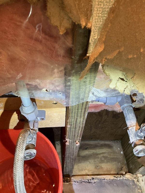 Repaired a leak at the bathroom faucet connection point by replacing deteriorated polybutylene fittings on both hot and cold water lines. Customer had previously removed drywall to expose the slow leak which was dripping into a bucket. Inspected surrounding area for water damage and confirmed proper connection integrity after replacement.