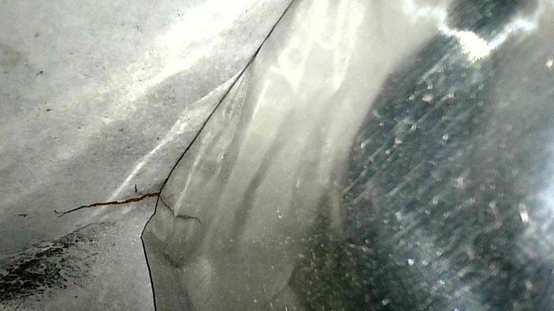 Responded to no-heat complaint for 15-year-old Trane XE90 system with running blower and consistent flashing red indicator light. Diagnostic inspection revealed cracked heat exchanger as confirmed by visual documentation. Replaced damaged heat exchanger to restore system functionality.