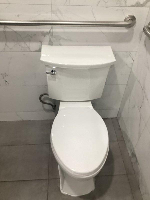 Responded to service call for handicap toilet in men's restroom that was overflowing. Diagnostic inspection revealed broken flush valve component. Shut off water supply, disassembled tank, and replaced defective flush valve part. Tested toilet operation after repair to confirm proper function with no further leaking or overflow issues.