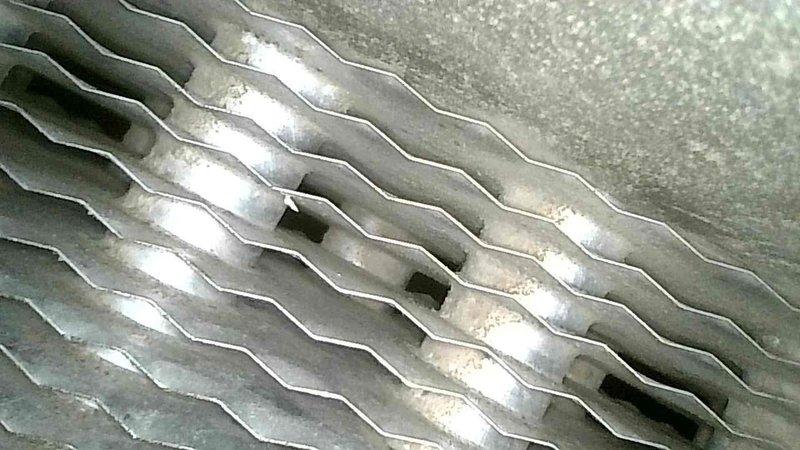 Performed comprehensive furnace tune-up on 20-year-old Heil unit. Inspected heat exchanger which showed concerning areas but no compromises detected. Identified blower wheel with excessive play and capacitor reading 7.1μF (below 10μF specification). Removed blower assembly to inspect secondary heat exchanger, finding no leaks. System operated normally during 20-minute test run with 45°F temperature rise. Recommended Furnace Replacement Program due to age and component condition.