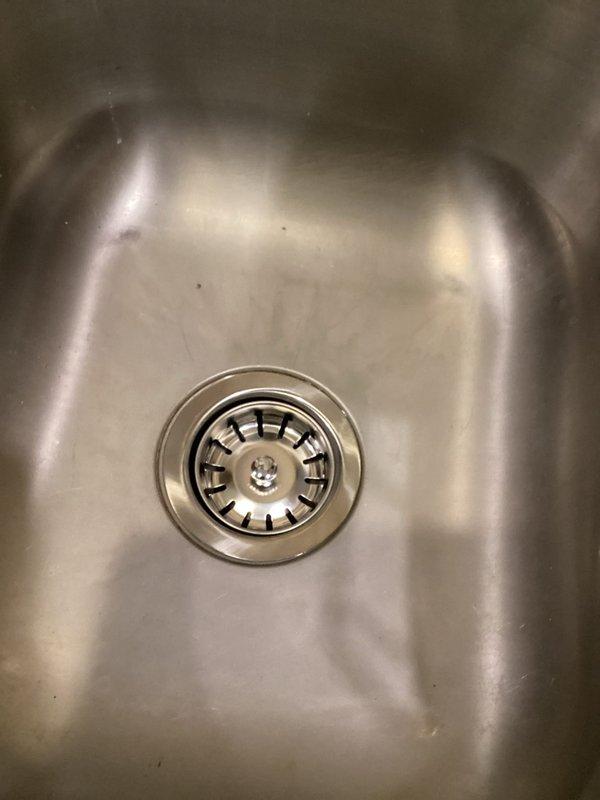 Inspected garbage disposal unit that was reported to be leaking. Removed existing disposal, bypassed the system, and installed a standard sink drain assembly with basket strainer to eliminate the disposal per customer request. Provided estimates for other reported plumbing issues including slow-flushing toilet, aging sump pump, leaking bathroom faucets, non-functioning sink stopper, kitchen faucet mobility issues, and water system contamination.