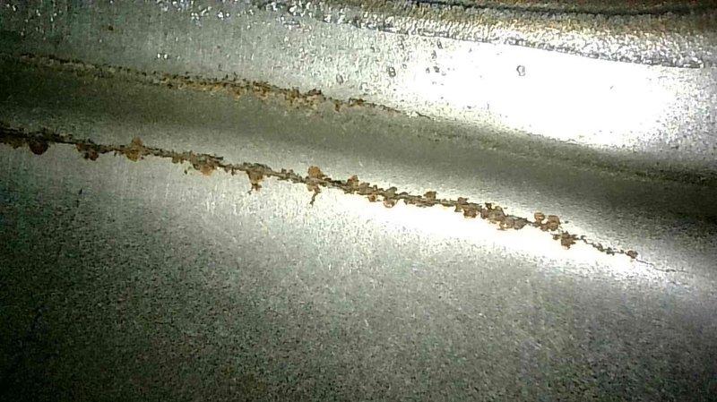 Diagnosed non-functional furnace (Whisper Heat model) exhibiting complete heating failure with initial visual inspection revealing two significant cracks in the heat exchanger. Discovered blown fuse likely caused by faulty thermostat wiring. Tagged unit out of service due to safety concerns, placed emergency service request, and communicated findings to customer's representative.