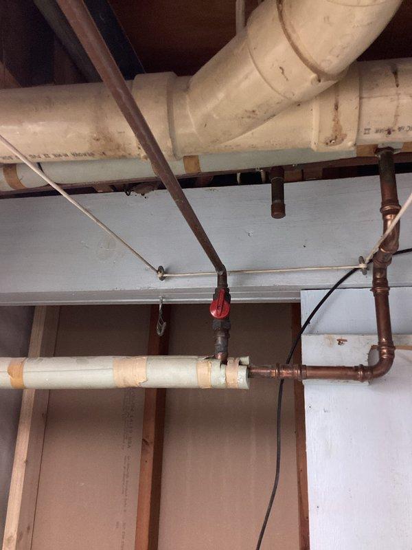 Installed new outdoor hose bibb by running an Apex water supply line from the basement's exposed joists to the exterior wall. Added a shutoff valve on the copper supply piping for serviceability and mounted the frost-free hose bibb through the stone facade exterior with appropriate waterproofing.