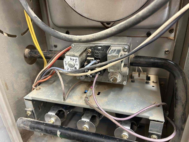 Responded to no-heat call for older furnace in workshop. Diagnosed tripped roll out switch, burnt wiring, and plugged burners. Cleaned affected burners, repaired damaged wires, and performed system test - unit now functioning properly. Noted high-pitched noise from inducer motor during operation which subsided.