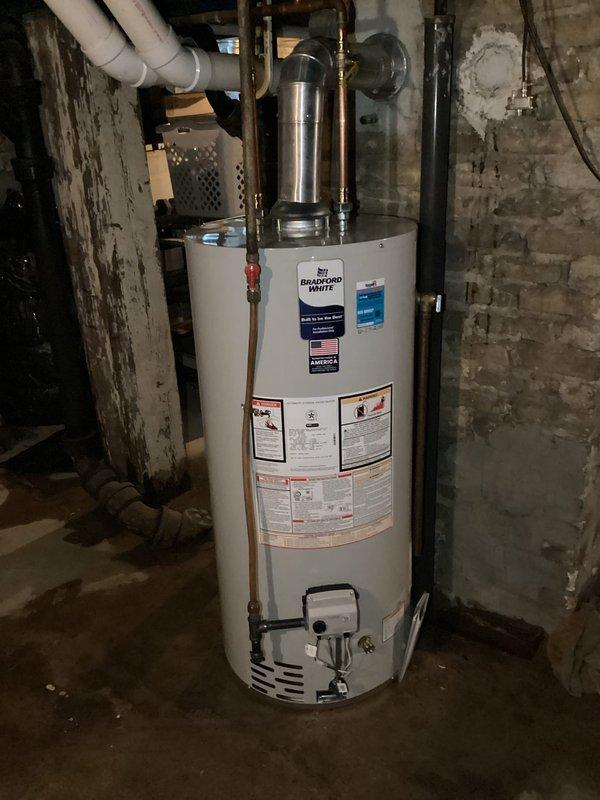 Replaced leaking Bradford White water heater with new unit in basement utility area. Installation included connecting copper water lines, PVC venting, and metal flue pipe to existing systems. Unit was properly secured and tested for proper operation before completion.