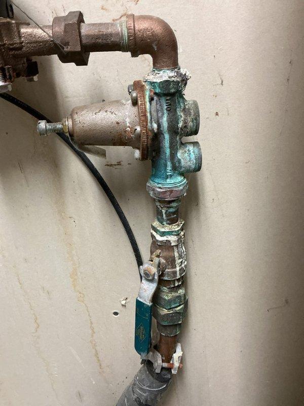 Conducted inspection of reported pilot light issue on customer's water heater. No functional problems were identified with the pilot light system; however, noted significant corrosion on water supply valves and piping. Observed elevated water pressure and evidence of leakage from the main line. Electrical panel inspection revealed proper connections to water heater. Recommended replacement of outdated water heater unit, installation of expansion tank, and rebuilding of the leaking main line to address corrosion issues and prevent future water damage.