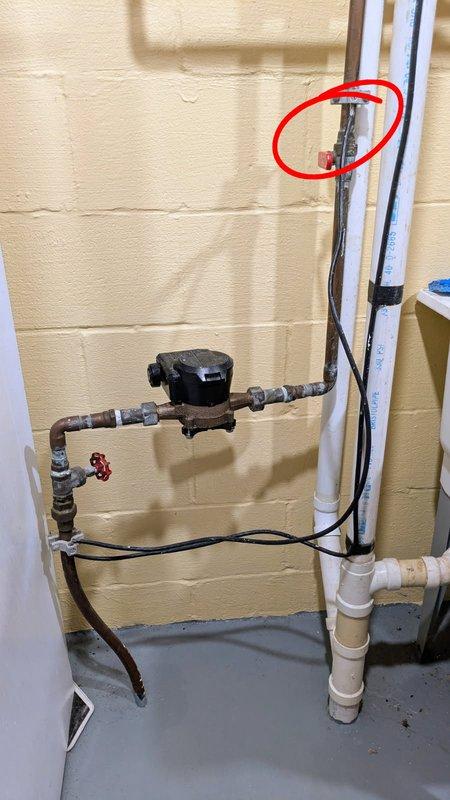 Repaired water line leak located above main shut-off valve at the primary water supply entry point. Leak was identified in copper piping connection near the circulation pump assembly on concrete block wall. Service restored full water functionality to home after completing repair and verifying system integrity.