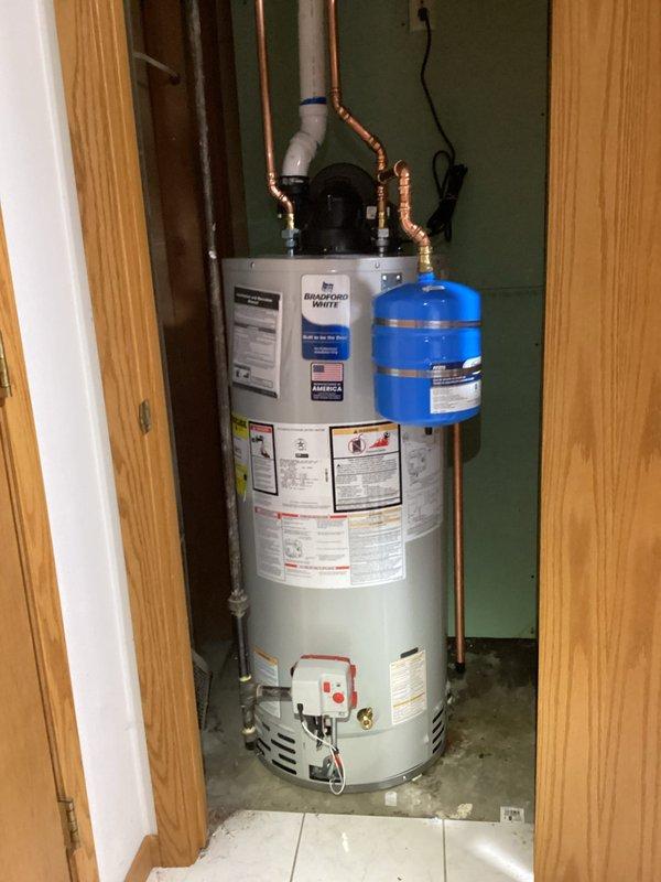 Successfully completed installation of a new 40-gallon water heater with proper copper line connections and expansion tank mounting. Unit was properly secured in utility closet with all required safety components and PVC venting installed to manufacturer specifications.