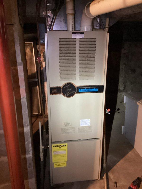 Responded to no heat call for aged Comfortmaker furnace (25-30 years old). Upon inspection, furnace initially presented with ignition failure, but system started correctly during testing and maintained proper flame. Observed significant rust deterioration around inducer motor housing with developing rust holes. Customer declined further diagnostics as unit is functioning at present but requested quote for complete system replacement due to age and condition.