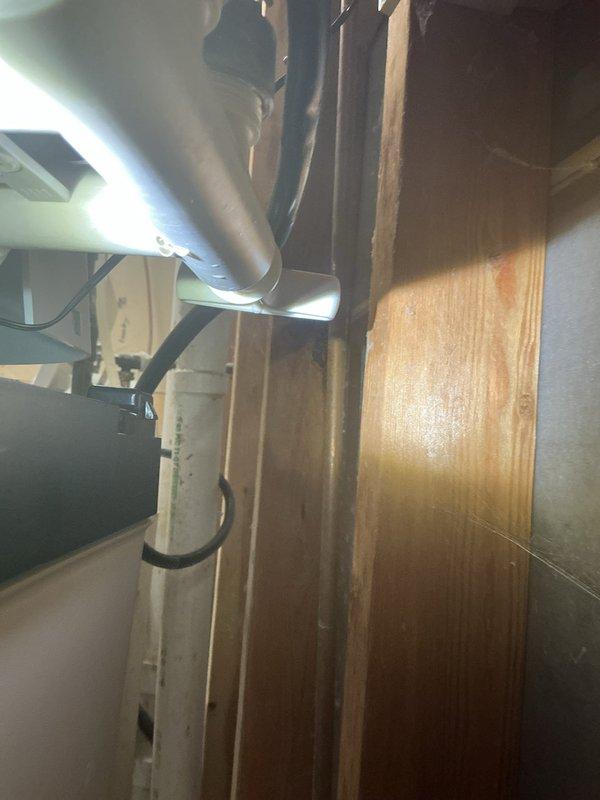 Responded to service call for a leaking water softener. Upon inspection, identified a failing bypass valve gasket causing the drip. Documented the damage with photos of the installation space and plumbing connections. Recommended complete replacement of the water softener as the most effective solution for the aging system.