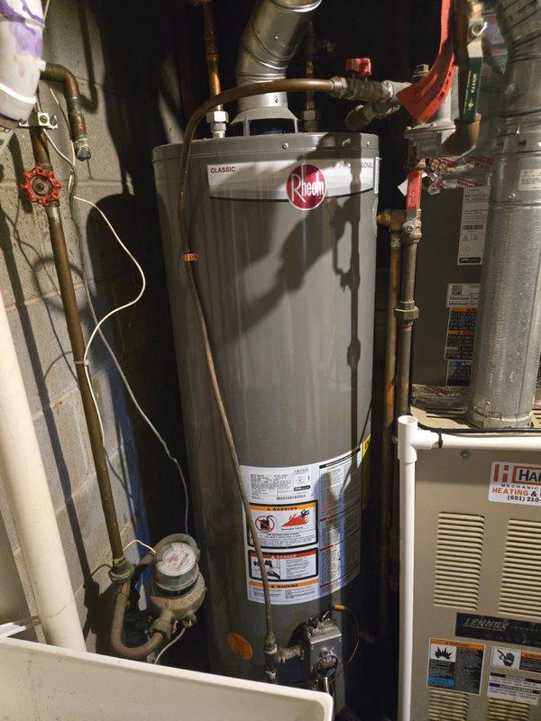 Responded to service call for a leaking water heater. Diagnosed that the relief valve was discharging due to an overheating gas valve. Discussed repair versus replacement options with homeowner. Inspected Rheem Classic water heater installation and surrounding utility area for additional issues.
