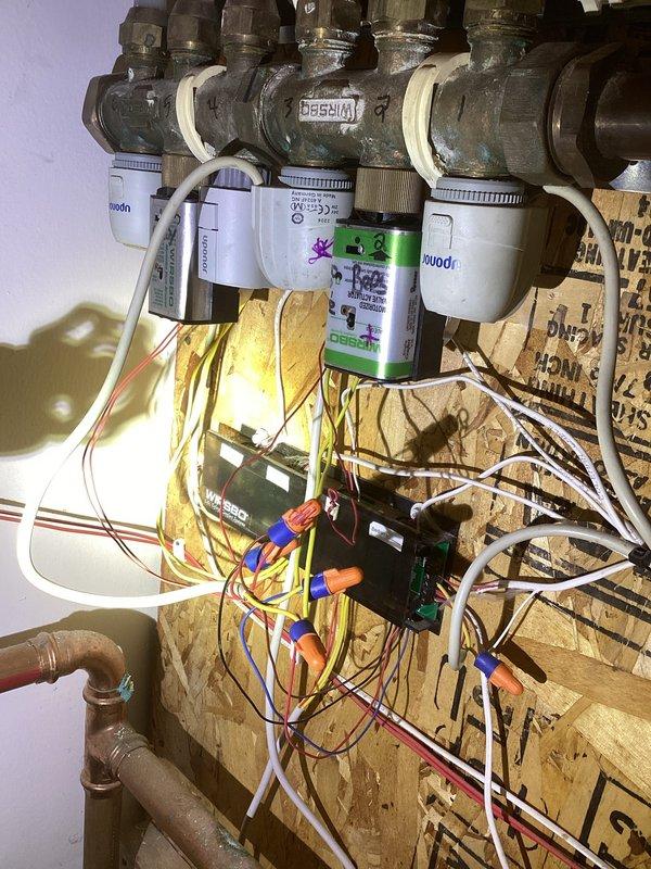 Diagnosed overheating issue in upper bedrooms of residence with geothermal system. Inspection revealed two defective zone power heads that were causing constant heat calls and temperature control problems. Removed and replaced malfunctioning actuators to restore proper zoning functionality and temperature regulation.