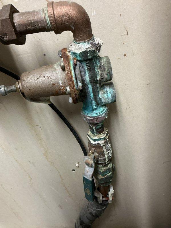 Completed return visit to finish plumbing repair service as scheduled. Replaced severely corroded pressure regulator valve that showed significant mineral deposits and blue-green oxidation. Installed new copper pipes with brass fittings to connect to existing water heating system, ensuring proper venting and connection to the main exhaust pipe.