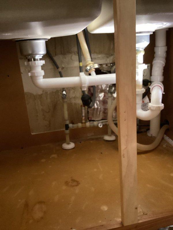 Responded to warranty service call for previously installed trap system where sink was clogged and garbage disposal was leaking. Successfully snaked drain to clear blockage and removed faulty garbage disposal unit, restoring proper drainage function to the kitchen sink.